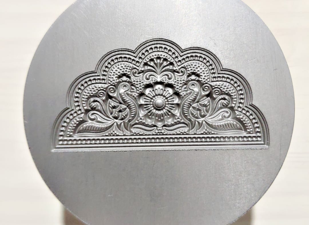 A pile of rusty metal gaskets, each with four holes, lies on a rough, dusty concrete floor. The image conveys an industrial, gritty tone.